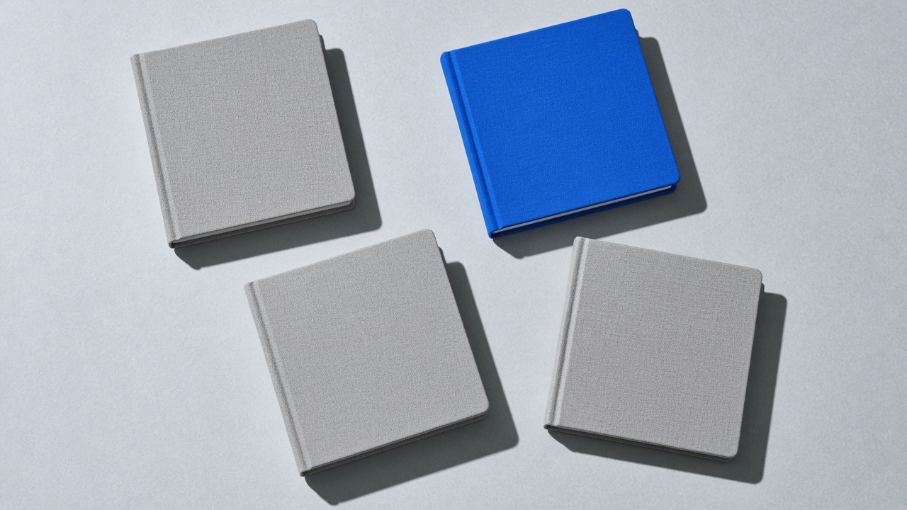 Grey and cobalt notebooks lined up on a pale table