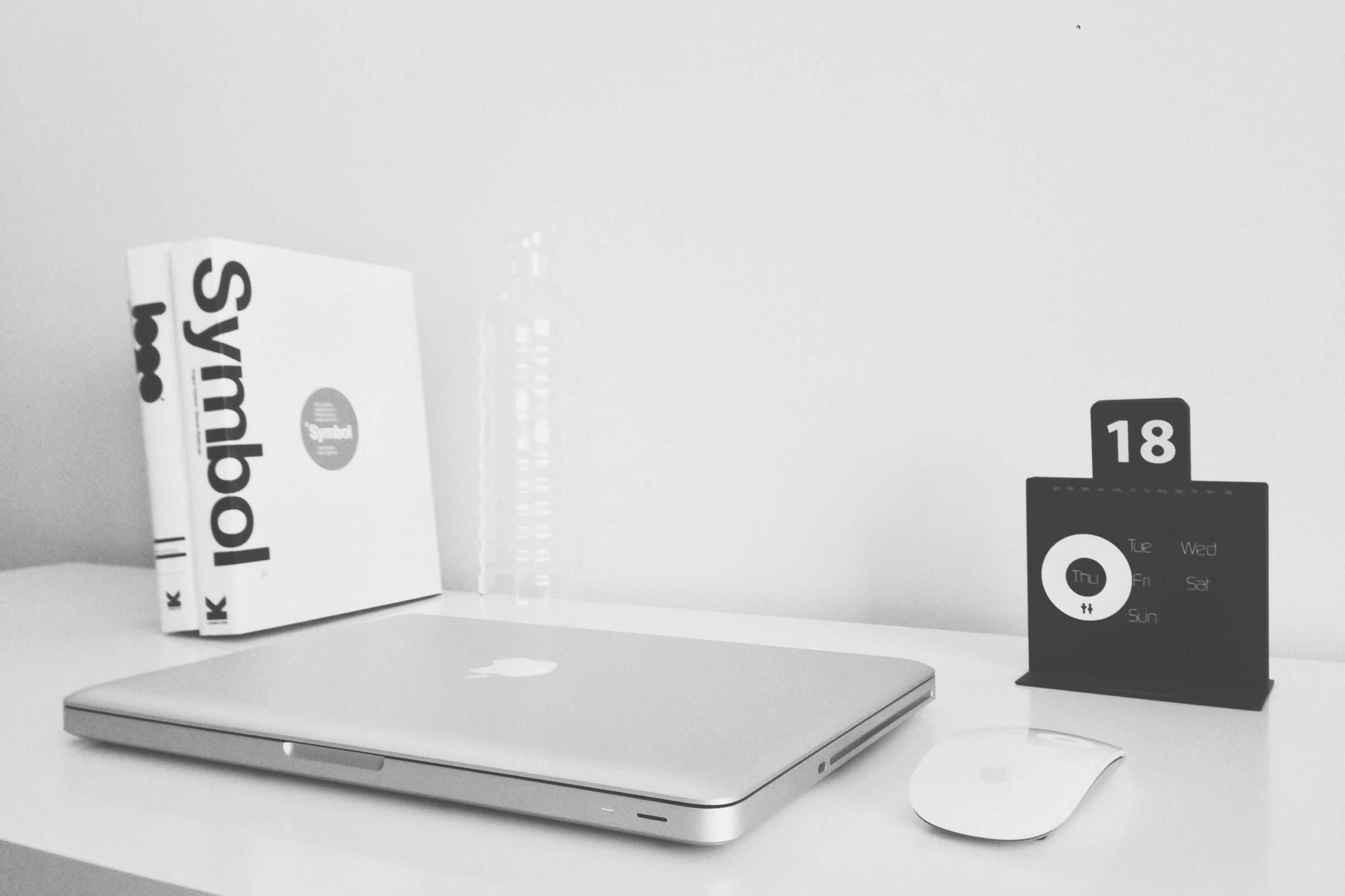 A laptop and a book on a white desk